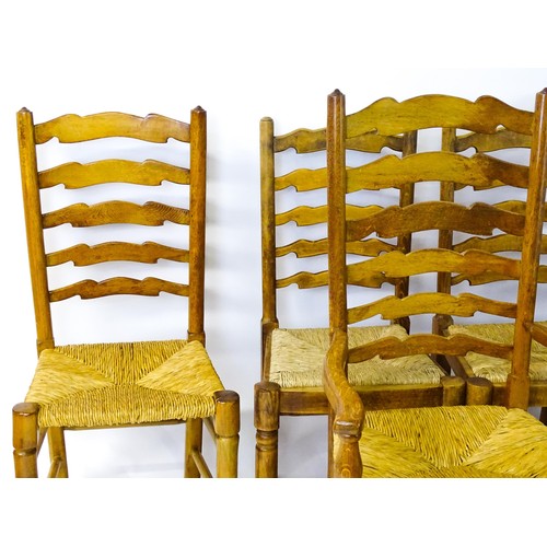 1392 - A group of eight mid 20thC oak dining chairs, with ladderbacks, envelope rush seats and raised on ta... 