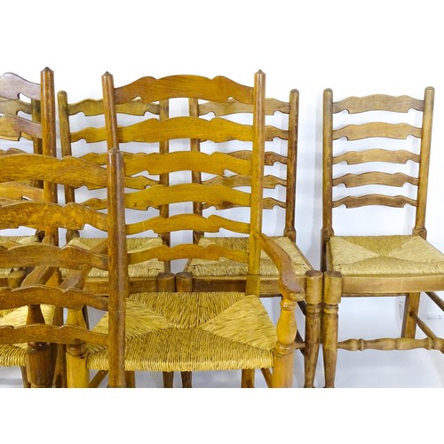 1392 - A group of eight mid 20thC oak dining chairs, with ladderbacks, envelope rush seats and raised on ta... 