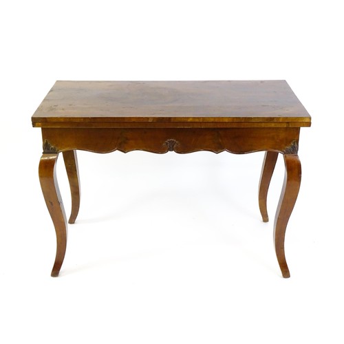 1399 - An early 20thC mahogany tea table of large proportions, the hinged rectangular top above a shell car... 