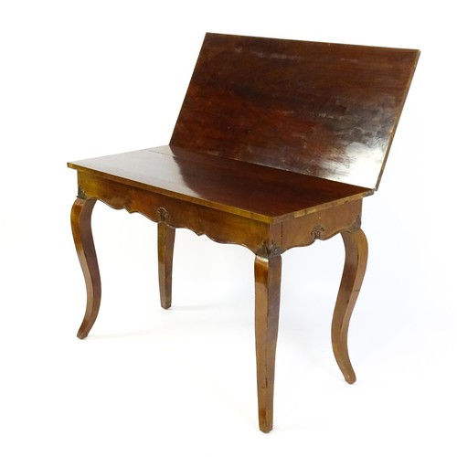 1399 - An early 20thC mahogany tea table of large proportions, the hinged rectangular top above a shell car... 