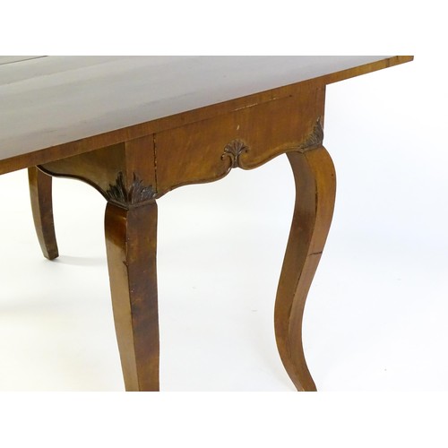 1399 - An early 20thC mahogany tea table of large proportions, the hinged rectangular top above a shell car... 