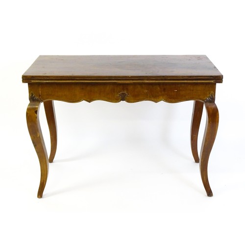 1399 - An early 20thC mahogany tea table of large proportions, the hinged rectangular top above a shell car... 