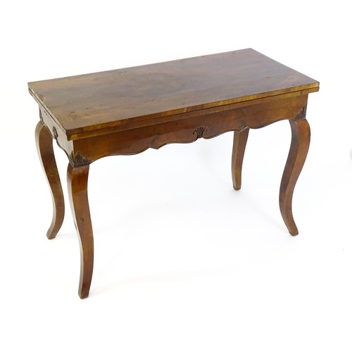 1399 - An early 20thC mahogany tea table of large proportions, the hinged rectangular top above a shell car... 