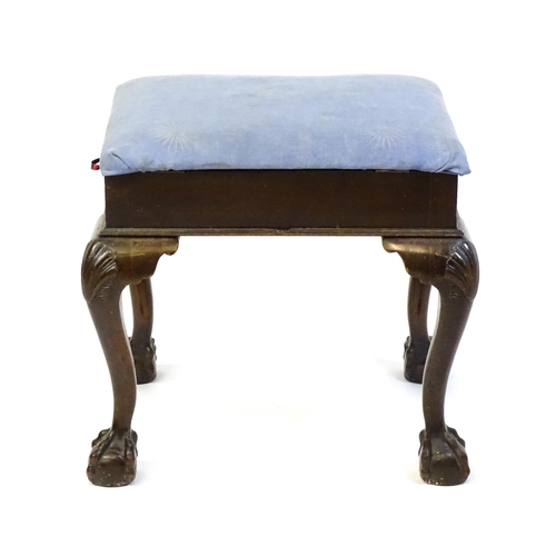 1401 - An early 20thC mahogany piano stool with an upholstered, hinged top above four cabriole legs with ac... 