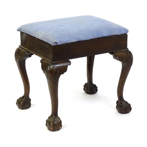 1401 - An early 20thC mahogany piano stool with an upholstered, hinged top above four cabriole legs with ac... 