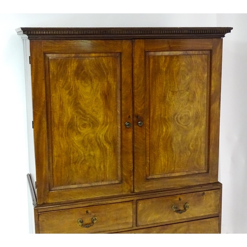 1404 - A mid to late 18thC mahogany linen press with dentil moulded cornice, two well figured panelled door... 