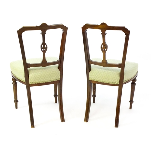 1407 - A pair of Edwardian walnut side chairs with carved cresting rails, pierced floral back splats and ra... 