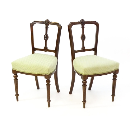 1407 - A pair of Edwardian walnut side chairs with carved cresting rails, pierced floral back splats and ra... 