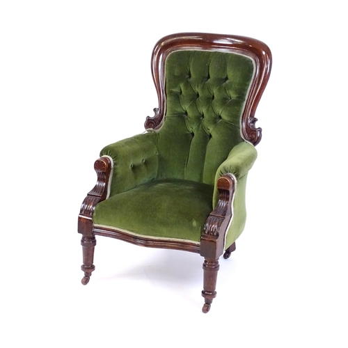 1412 - A late 19thC mahogany armchair with a moulded spoon back, deep buttoned backrest, sprung seat and ca... 