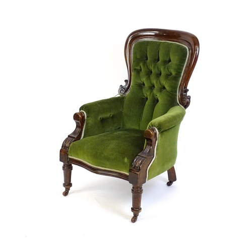 1412 - A late 19thC mahogany armchair with a moulded spoon back, deep buttoned backrest, sprung seat and ca... 