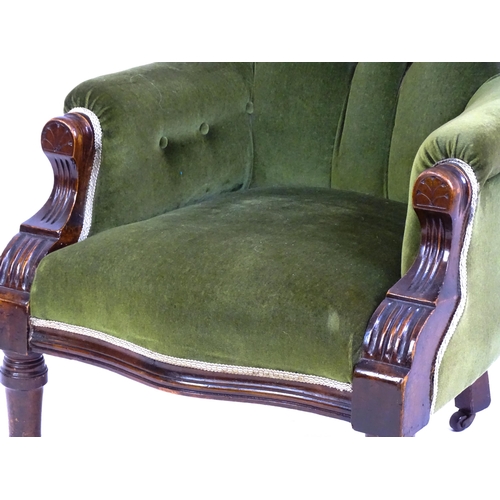 1412 - A late 19thC mahogany armchair with a moulded spoon back, deep buttoned backrest, sprung seat and ca... 