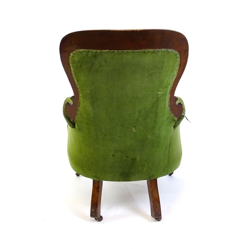 1412 - A late 19thC mahogany armchair with a moulded spoon back, deep buttoned backrest, sprung seat and ca... 