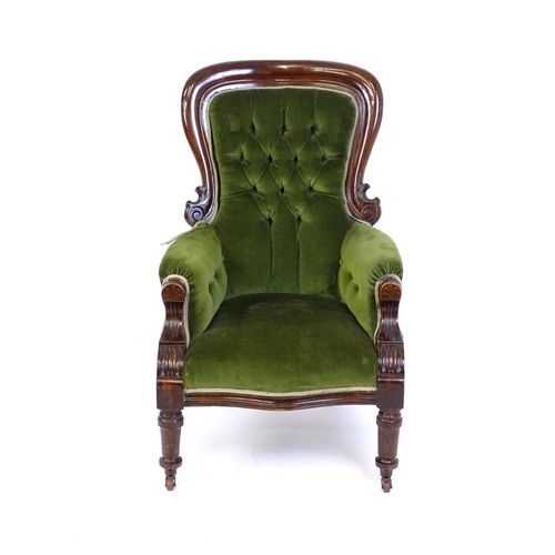 1412 - A late 19thC mahogany armchair with a moulded spoon back, deep buttoned backrest, sprung seat and ca... 