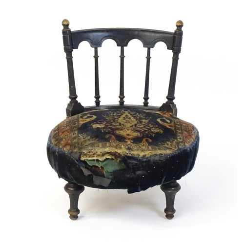 1413 - A late 19thC nursing chair with a bowed top rail surmounted by turned finials, turned back splats an... 