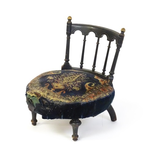 1413 - A late 19thC nursing chair with a bowed top rail surmounted by turned finials, turned back splats an... 