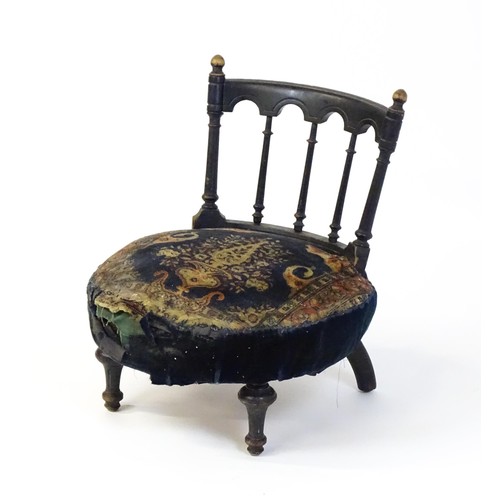 1413 - A late 19thC nursing chair with a bowed top rail surmounted by turned finials, turned back splats an... 