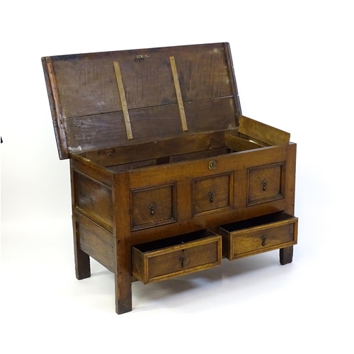 1415 - A late 17thC oak mule chest with a hinged lid above three faux drawers and two short drawers above s... 