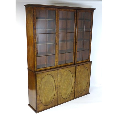 1416 - A large Georgian mahogany bookcase with a moulded cornice above three astragal glazed doors and the ... 