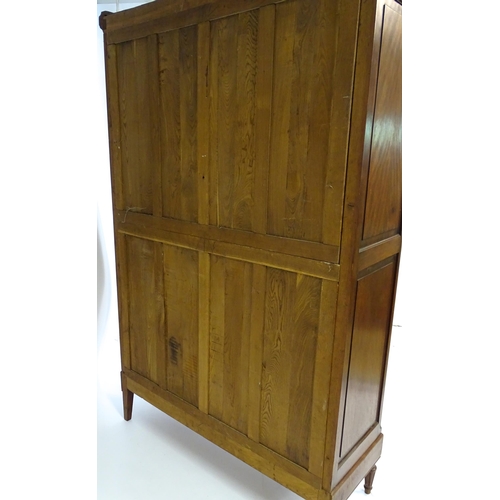 1417 - A late 19thC continental walnut armoire, with a carved floral pediment above a large mirrored door f... 