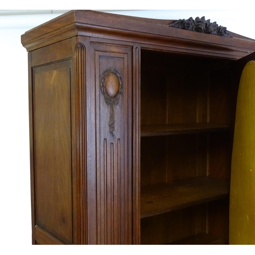 1417 - A late 19thC continental walnut armoire, with a carved floral pediment above a large mirrored door f... 