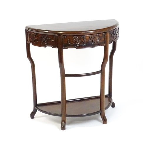 1422 - A late 19thC / early 20thC Qing dynasty demi lune table, with a carved front, a frieze drawer and ra... 