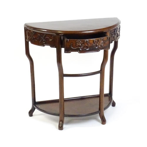 1422 - A late 19thC / early 20thC Qing dynasty demi lune table, with a carved front, a frieze drawer and ra... 