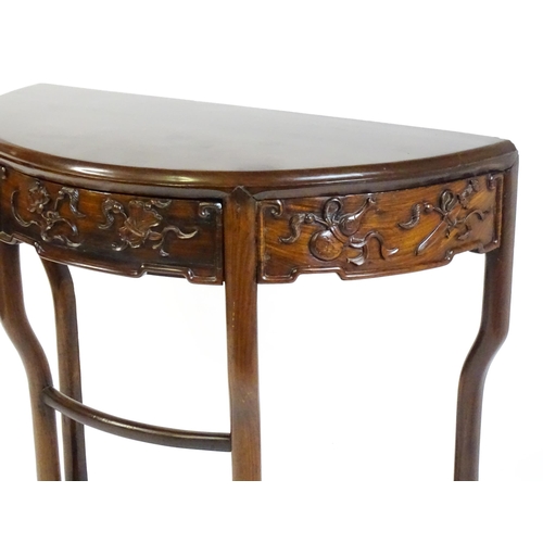 1422 - A late 19thC / early 20thC Qing dynasty demi lune table, with a carved front, a frieze drawer and ra... 