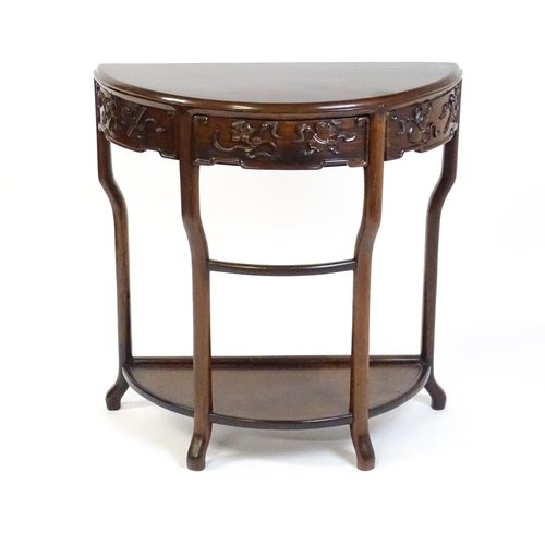 1422 - A late 19thC / early 20thC Qing dynasty demi lune table, with a carved front, a frieze drawer and ra... 