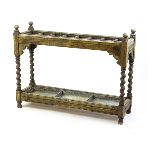 1425 - A late 19thC stick stand with sixteen sections above four barley twist supports, carved sides and a ... 