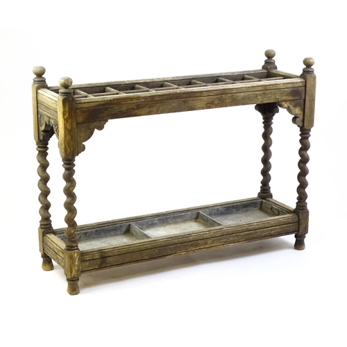 1425 - A late 19thC stick stand with sixteen sections above four barley twist supports, carved sides and a ... 