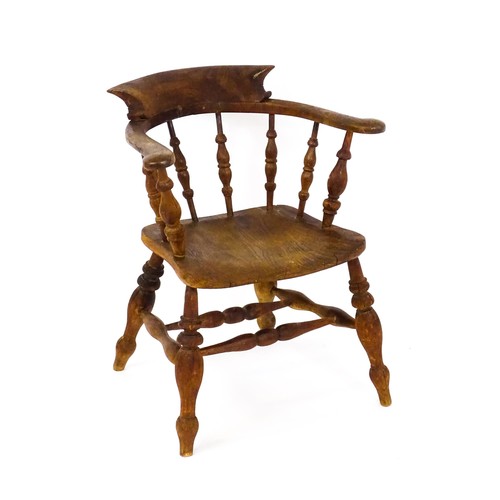 1426 - A late 19thC / early 20thC smokers bow chair, with a bowed backrest, turned tapering supports and a ... 