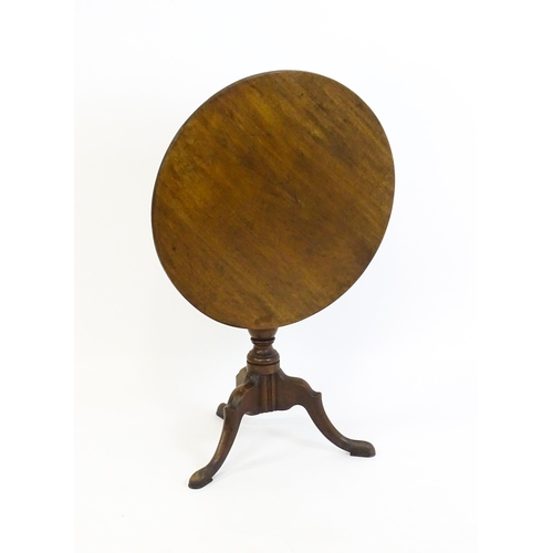 1428 - A George III mahogany tripod table with a circular reeded top above a turned pedestal and three well... 