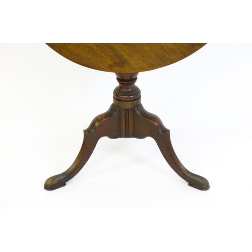 1428 - A George III mahogany tripod table with a circular reeded top above a turned pedestal and three well... 