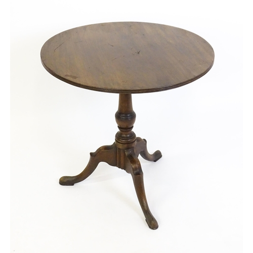 1428 - A George III mahogany tripod table with a circular reeded top above a turned pedestal and three well... 