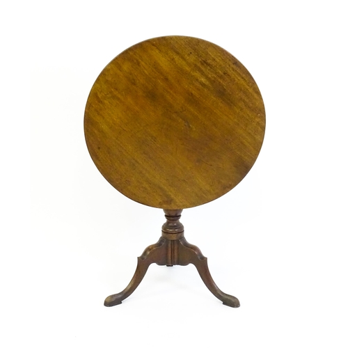 1428 - A George III mahogany tripod table with a circular reeded top above a turned pedestal and three well... 