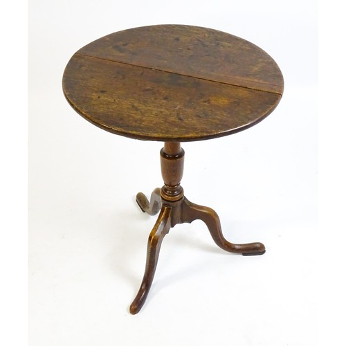 1429 - A late 18thC oak tripod table with a circular top above a tapering turned pedestal and three cabriol... 