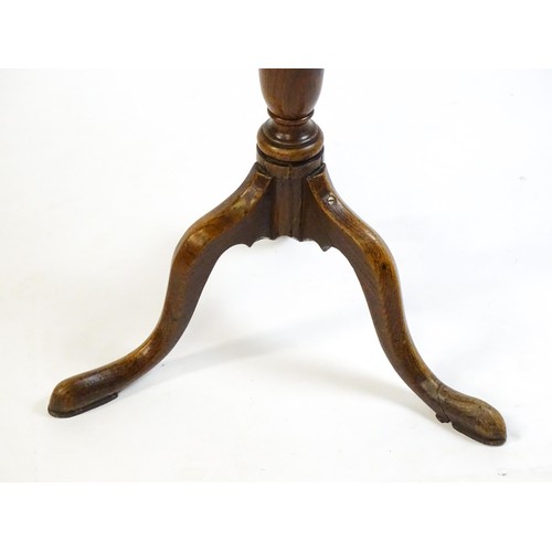 1429 - A late 18thC oak tripod table with a circular top above a tapering turned pedestal and three cabriol... 