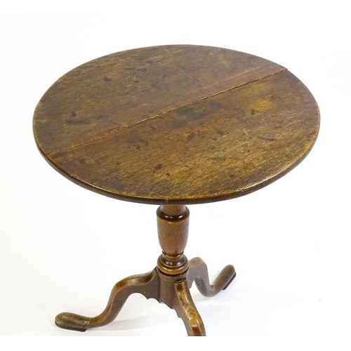 1429 - A late 18thC oak tripod table with a circular top above a tapering turned pedestal and three cabriol... 