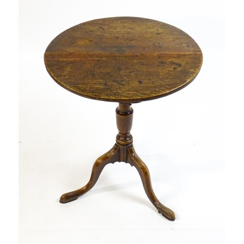 1429 - A late 18thC oak tripod table with a circular top above a tapering turned pedestal and three cabriol... 