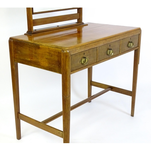 1430 - A mid 20thC Art Deco walnut dressing table, with a squared mirror above three short drawers with bra... 