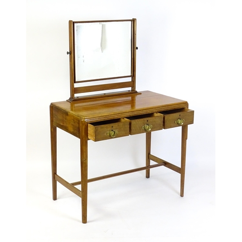 1430 - A mid 20thC Art Deco walnut dressing table, with a squared mirror above three short drawers with bra... 