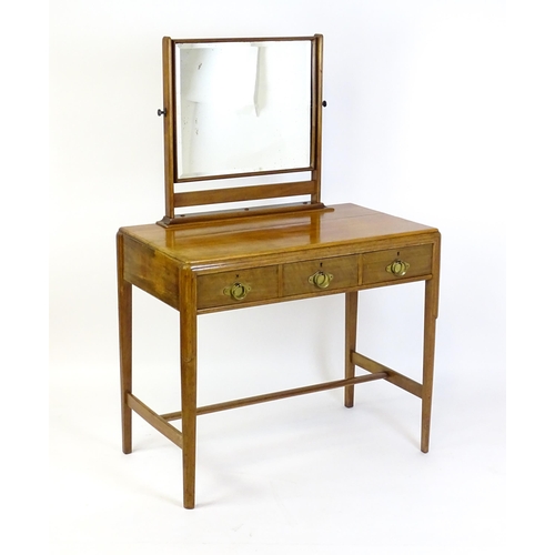 1430 - A mid 20thC Art Deco walnut dressing table, with a squared mirror above three short drawers with bra... 