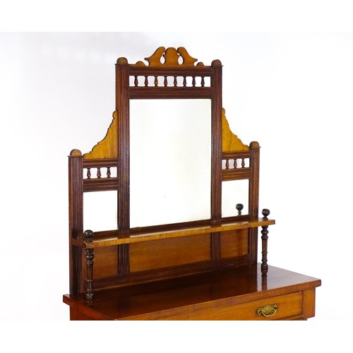 1438 - An Aesthetic movement mahogany chiffonier with a mirrored back, galleries of turned finials and reed... 