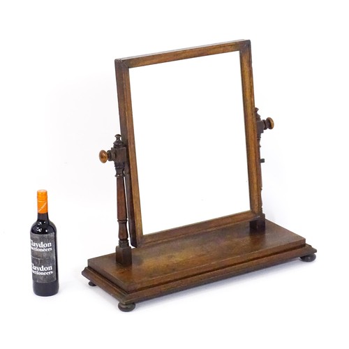 1439 - A Victorian mahogany mirror, the rectangular surround supported by turned uprights to either side su... 