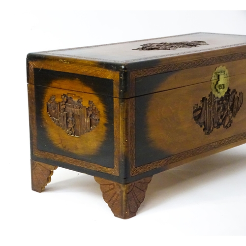 1441 - An early 20thC oriental camphor wood trunk with sides, lid and front, depicting figures within a lan... 