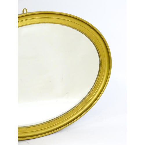 1443 - An early 20thC oval gilt mirror. with a moulded surround. 33