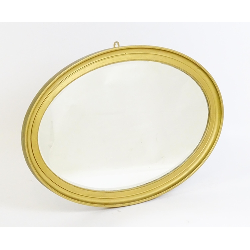 1443 - An early 20thC oval gilt mirror. with a moulded surround. 33