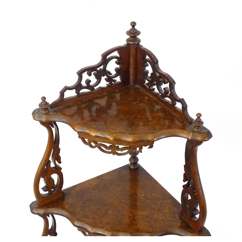 1446 - A 19thC burr walnut corner etagere, having pierced carved decoration to each tier and the supports, ... 