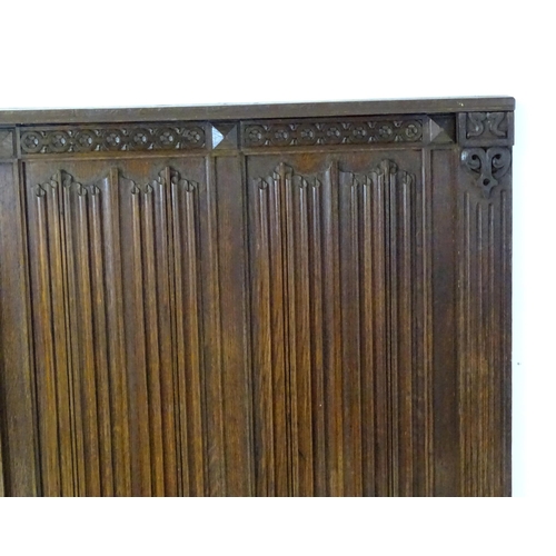 1448 - An early 20thC oak panel with carved rosettes and linen fold decoration. 33