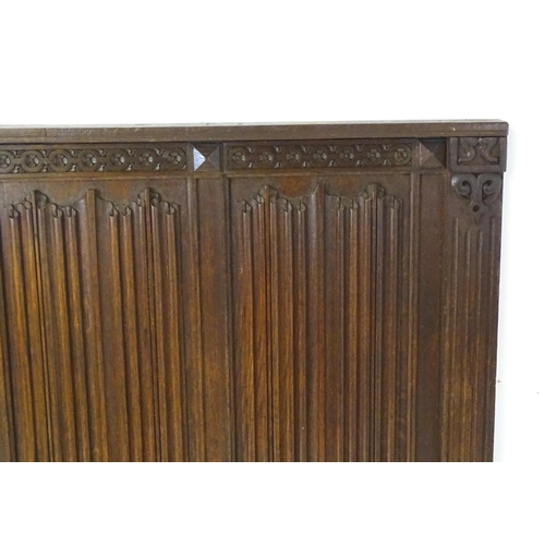 1448 - An early 20thC oak panel with carved rosettes and linen fold decoration. 33